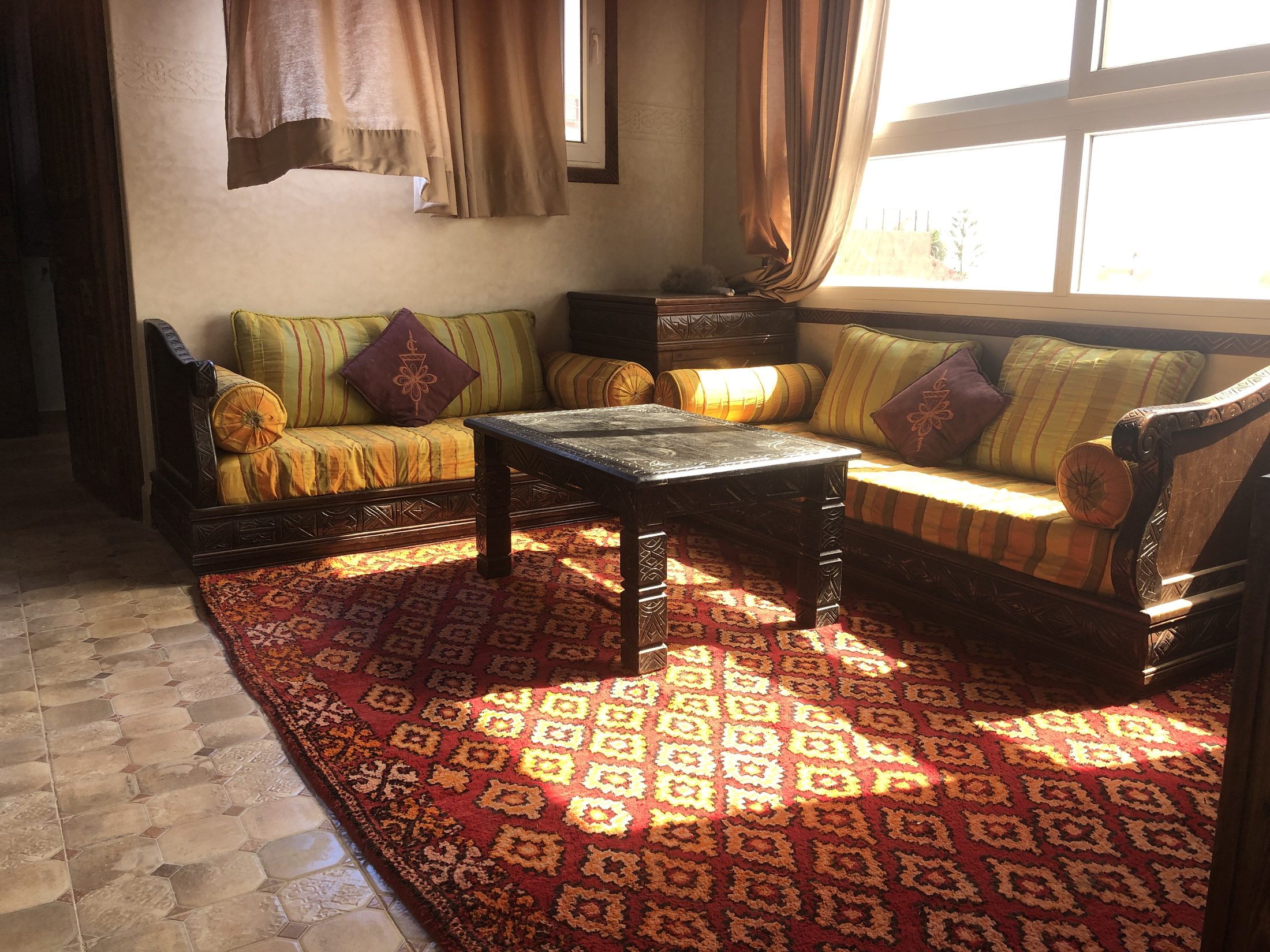 Moroccan salon with long carved table and painted windows