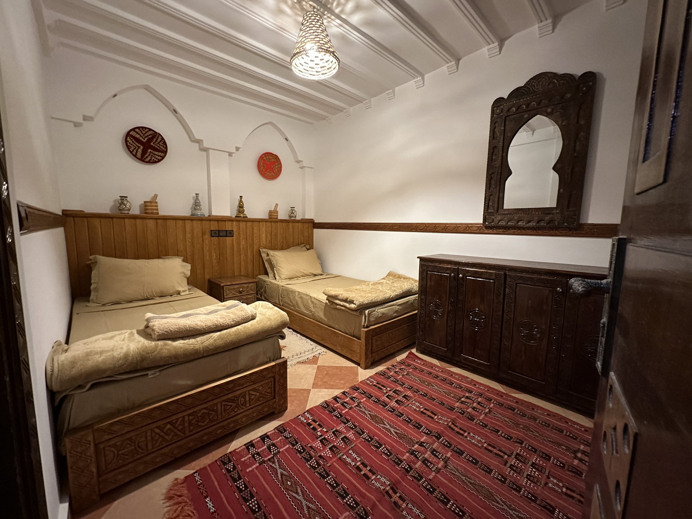 Shared twin room with two single beds and painted side tables