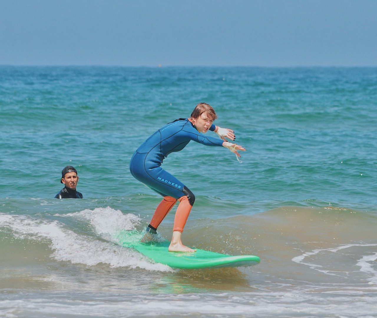 Surfer carving along a clean turquoise wave at Taghazout Bay