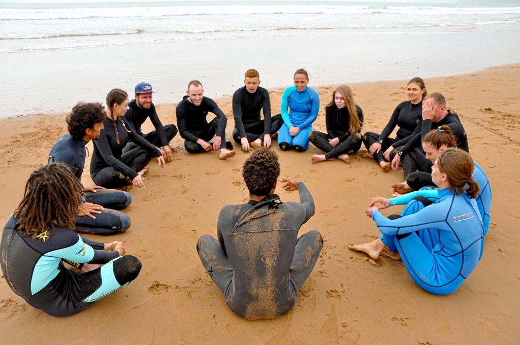 Small group surf lesson waiting for waves on soft-top boards